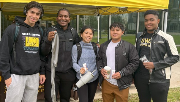 Students holding up items they received from Belonging and Care pop up tent.