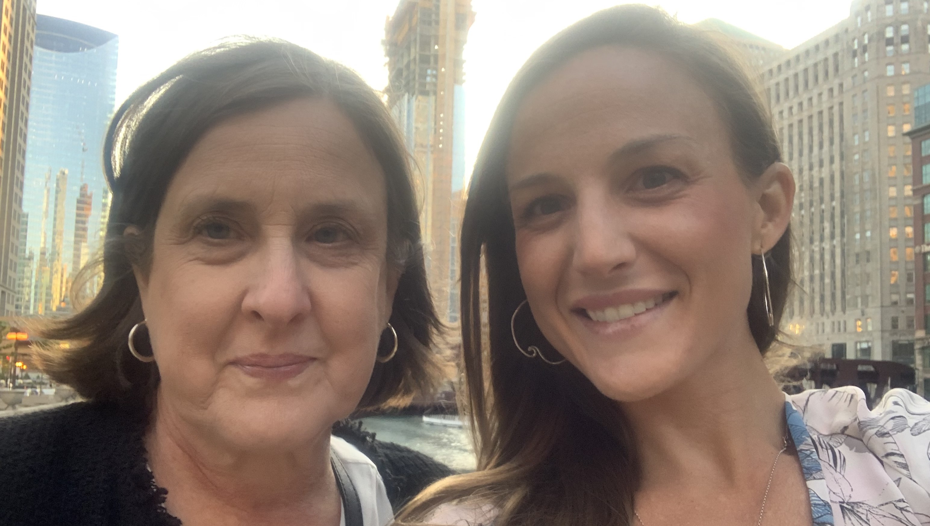 Becky and a woman taking a selfie in front of a city line
