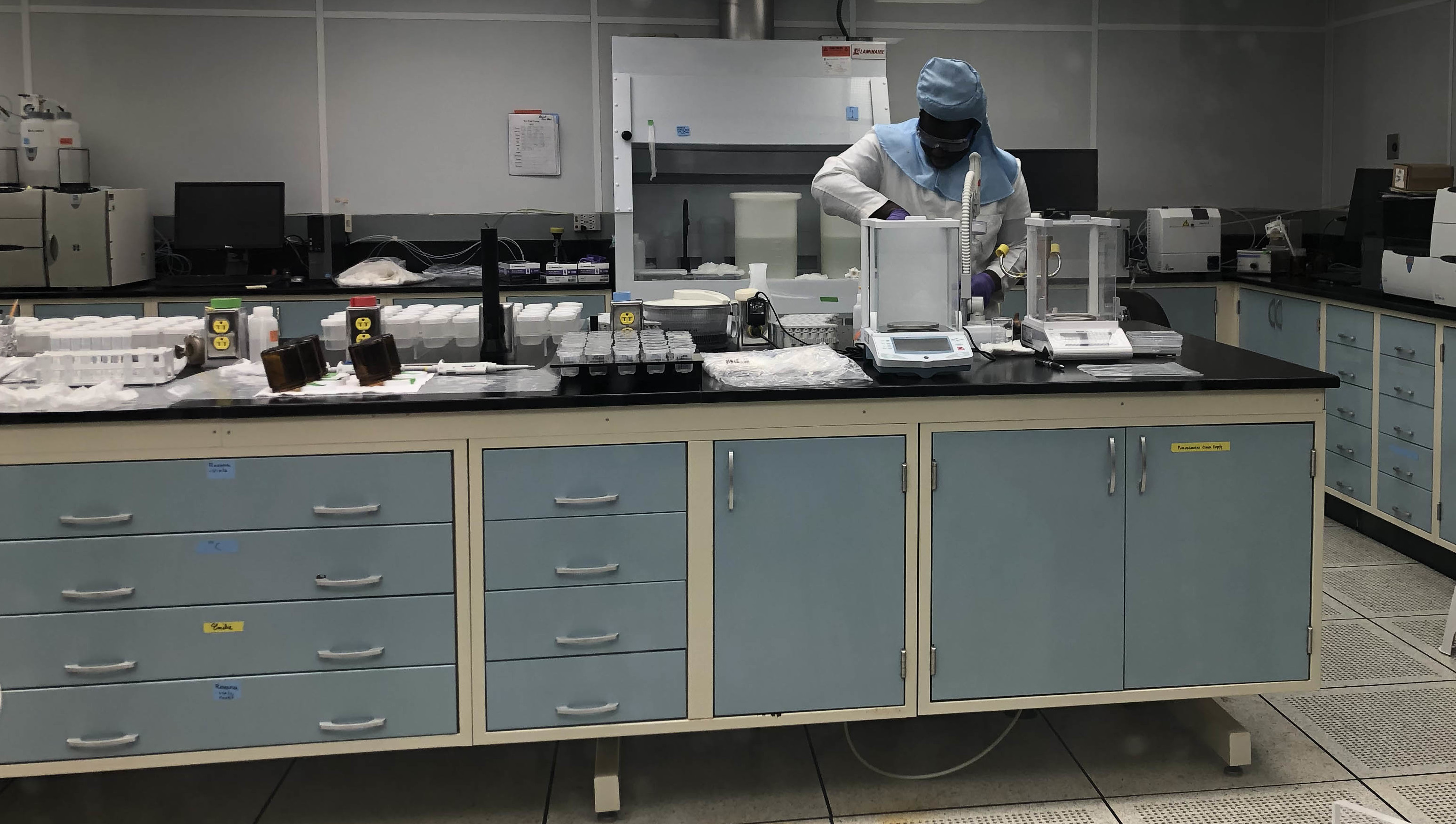 Intern Keron Mensah working in a class-100 clean room at the Byrd Center in lab gear doing research
