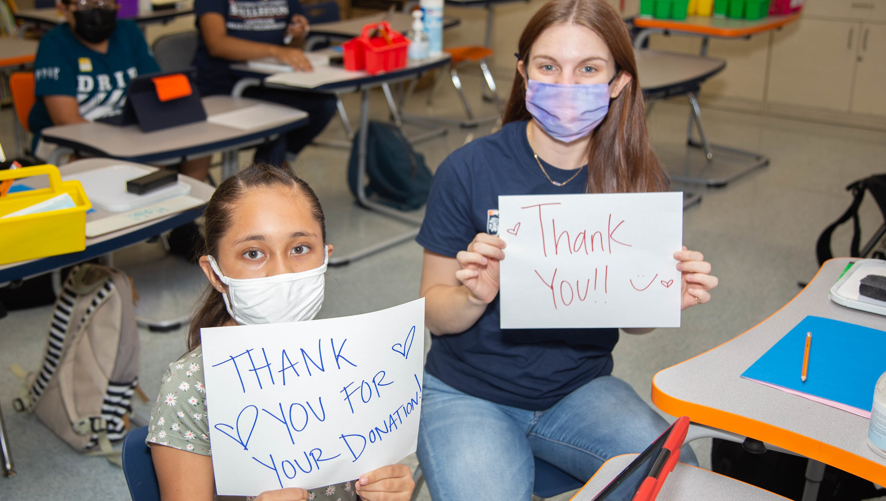 Child and adult holding thank you sign