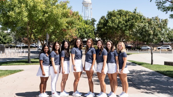 Women’s Golf Team standing in front of the UC Davis water tower.