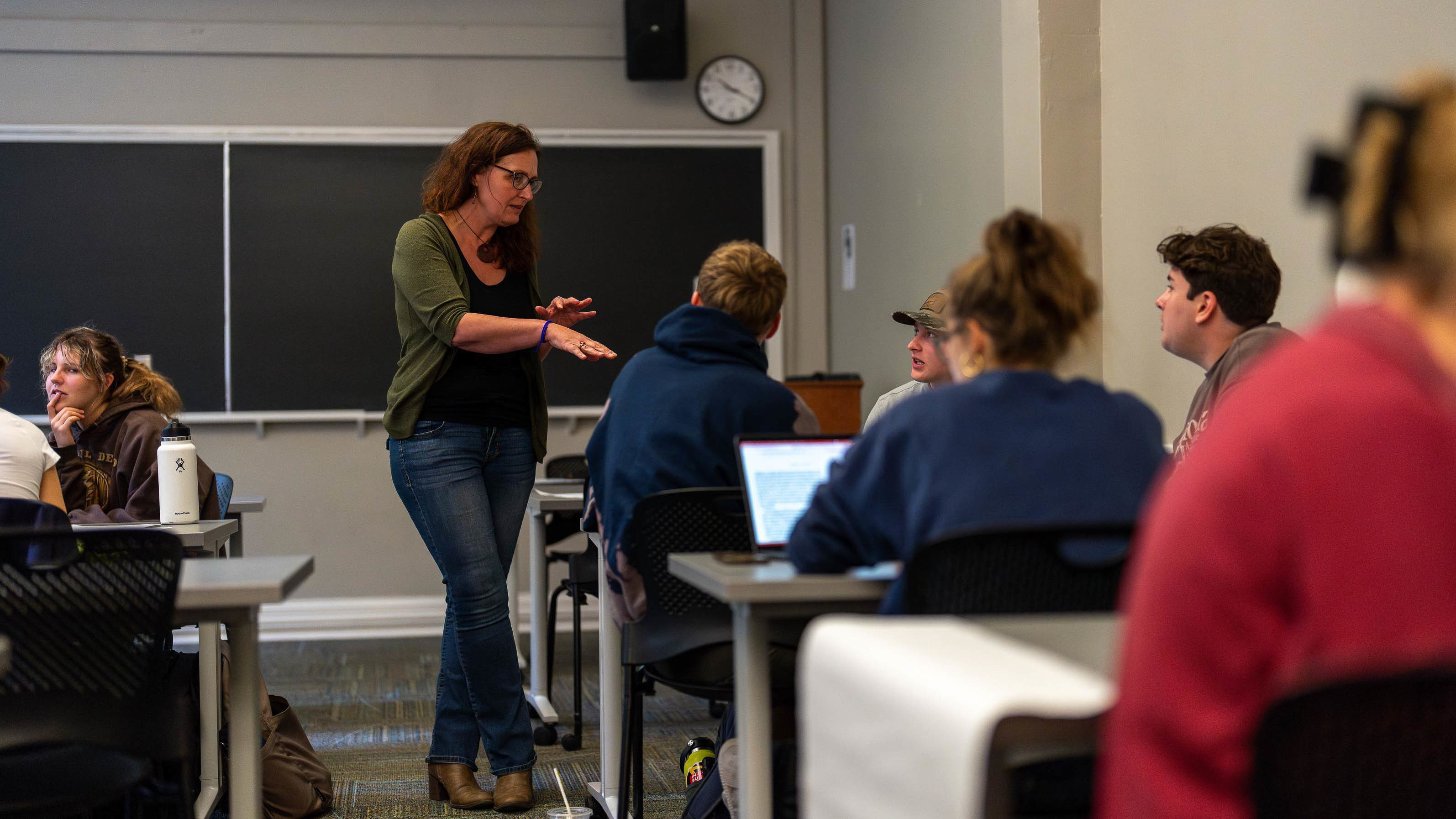Geography Professor Leslie McLees working with students in a course.