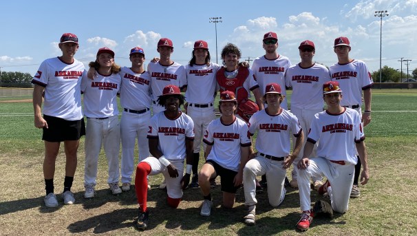 Members of the University of Arkansas club baseball team stand together on the baseball field