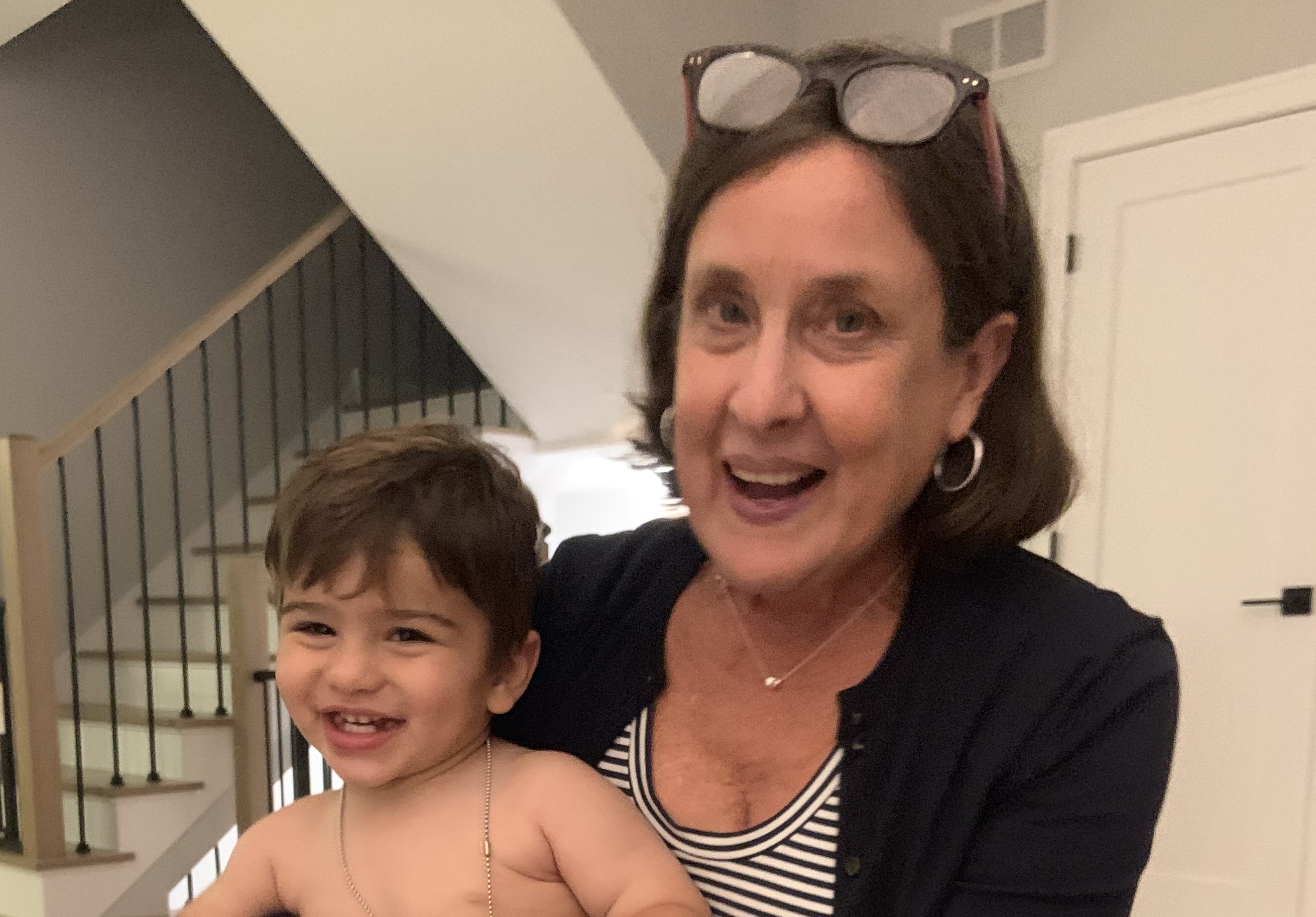 Becky holing a young child in a home