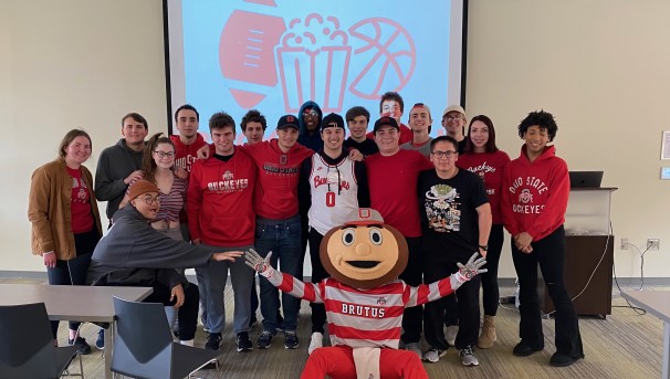 Group of Ohio State students standing with Brutus Buckeye at a meet and greet