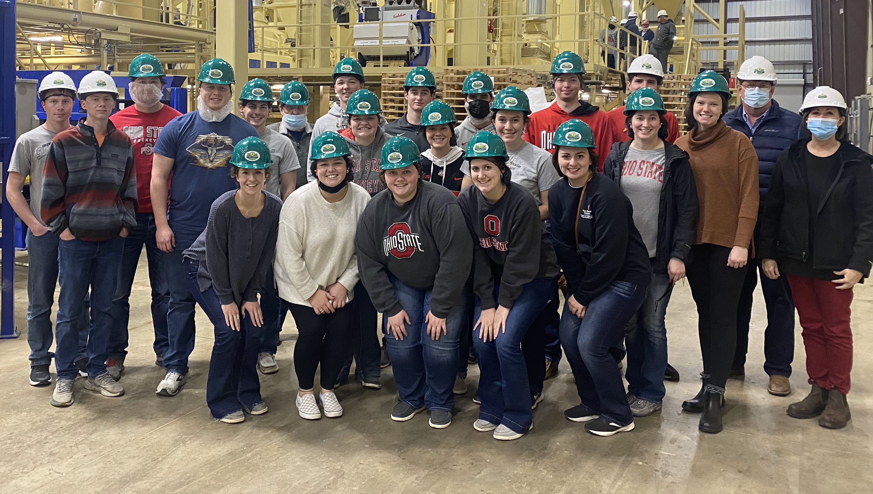 Students wear hard hats during the peanut shelling facility tour during the 2022 club trip