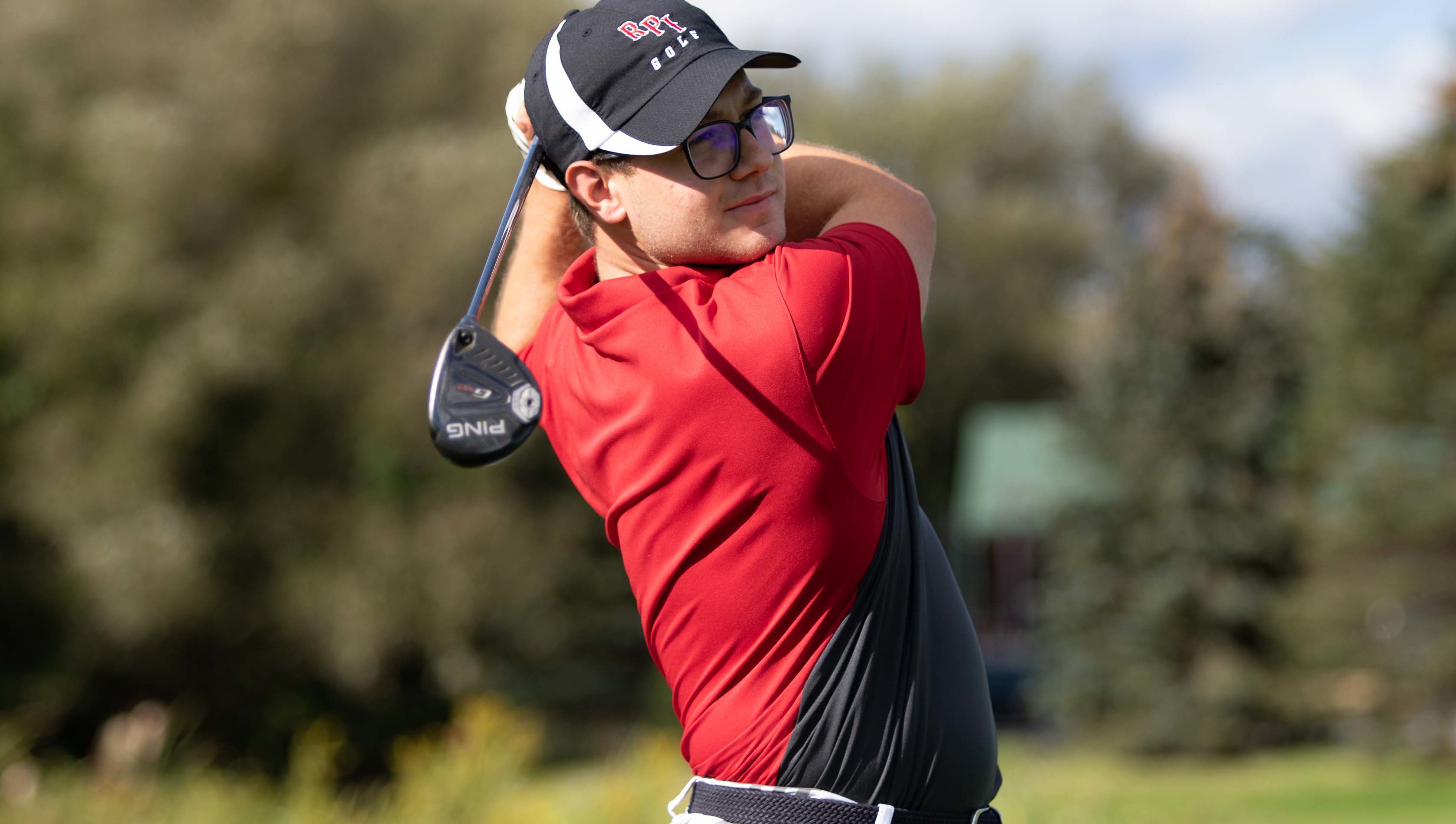 An RPI golf player looking at the ball after he hit it.