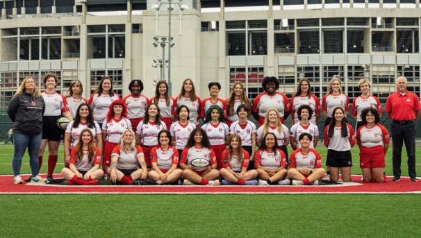 Ohio State Women's Club Rugby players and coaches on turf smiling for a group photo