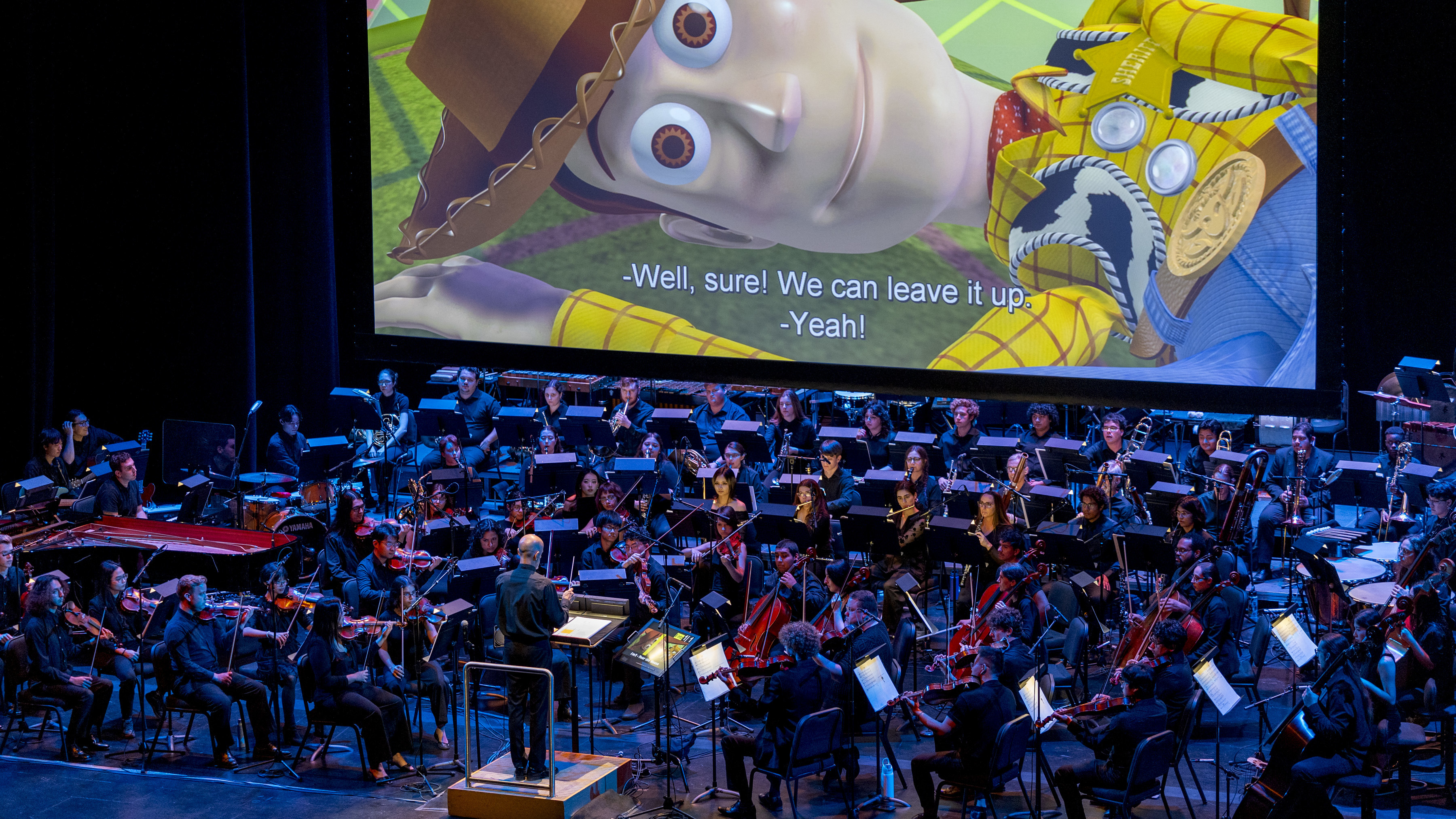Orchestra performing in front of the movie "Toy Story"