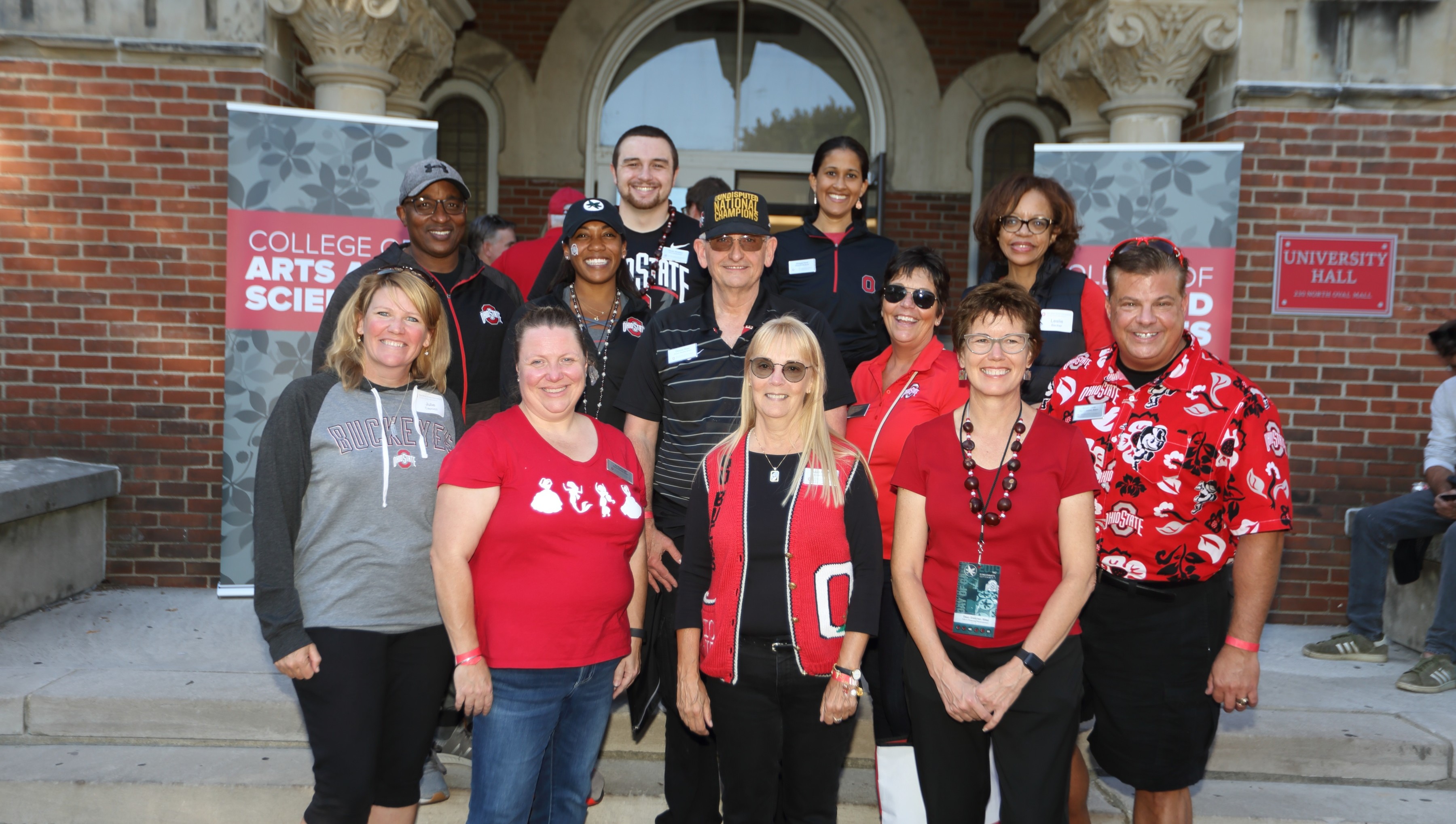 The 2019 Alumni Society Board in front of banners for the College of Arts and Sciences