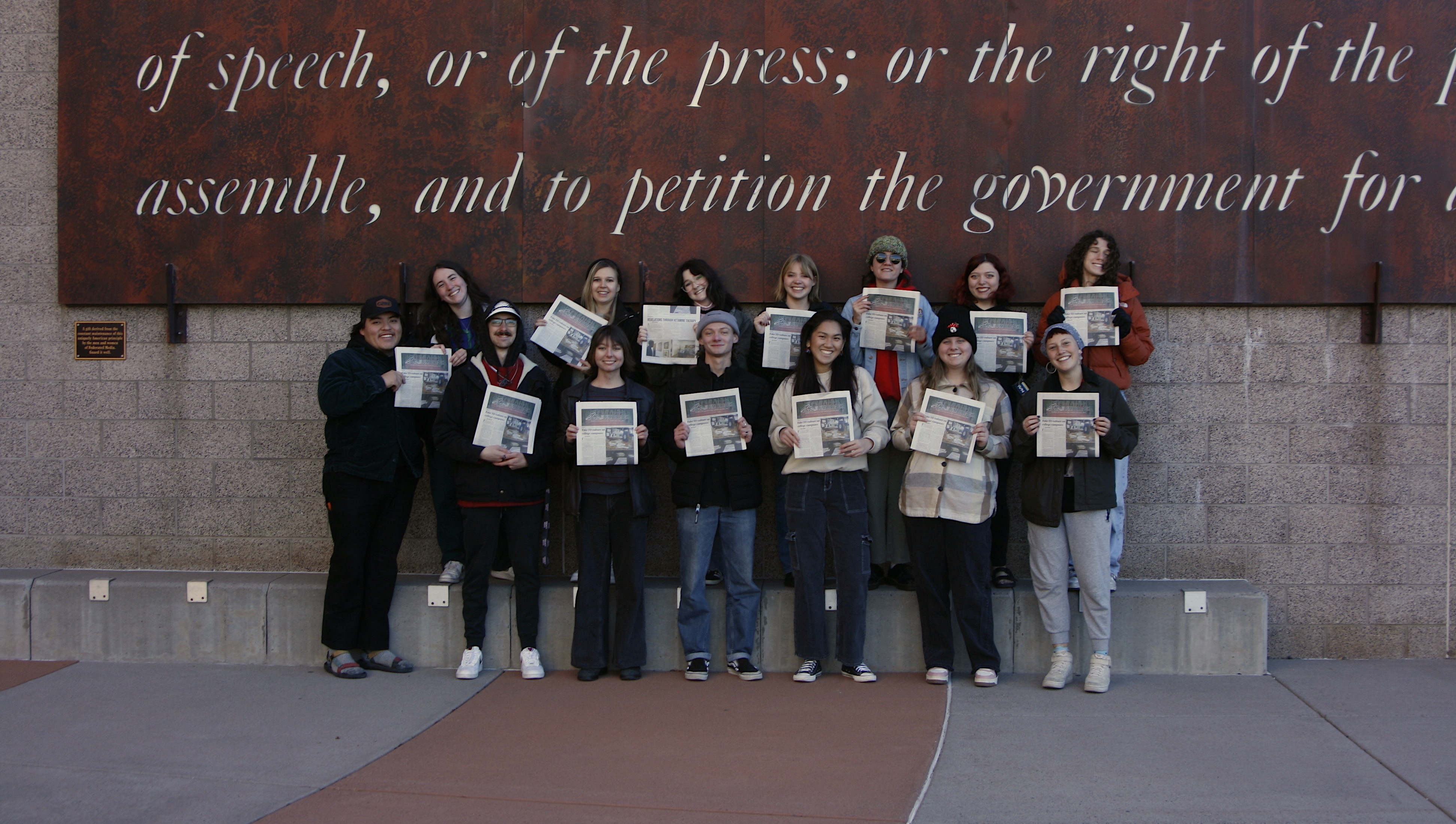 Staff of The Lumberjack hold the Taboo Issue in front of the School of Communication at NAU.