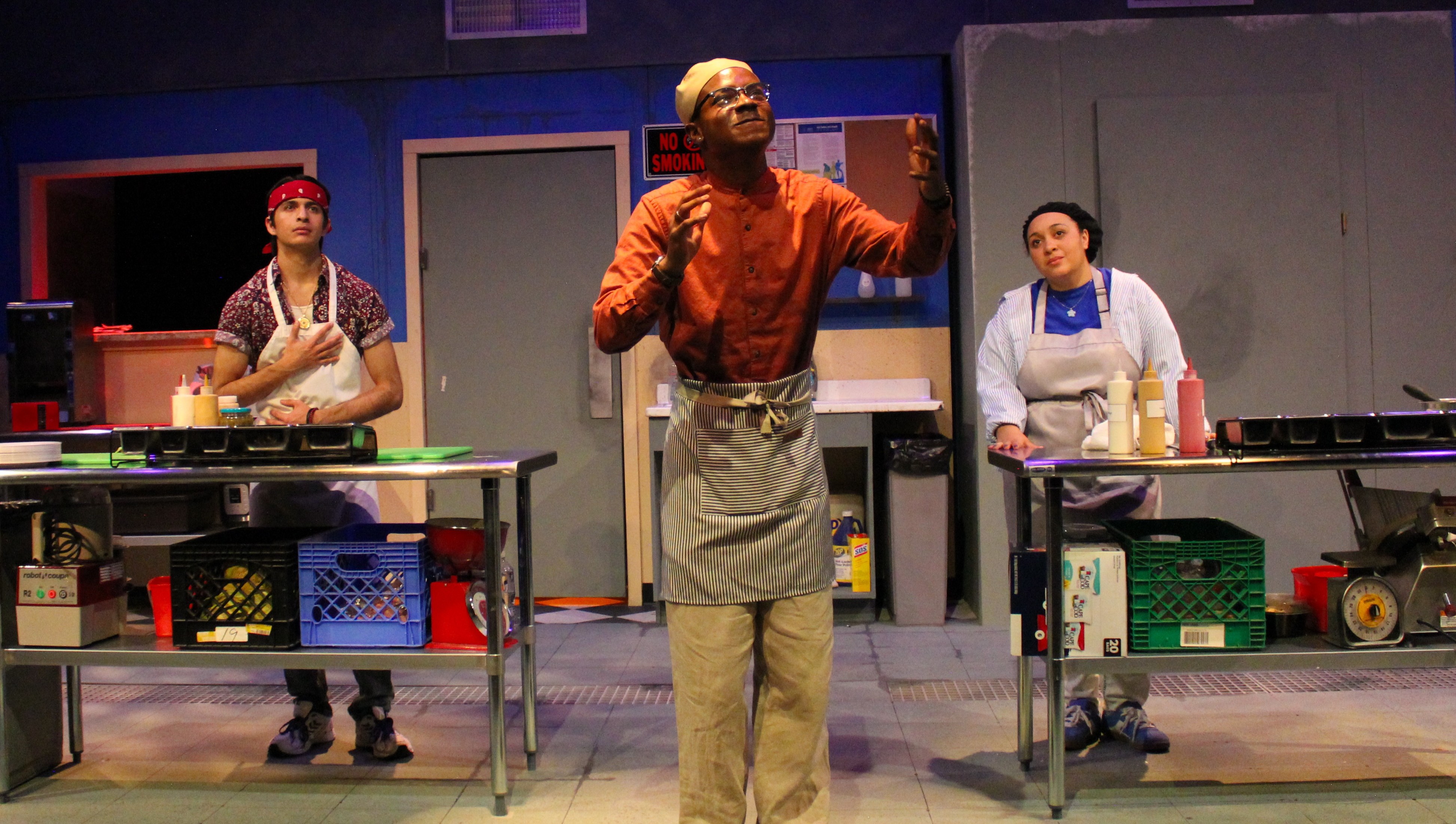 Shows three actors in the production of Clyde's at Northern Arizona University