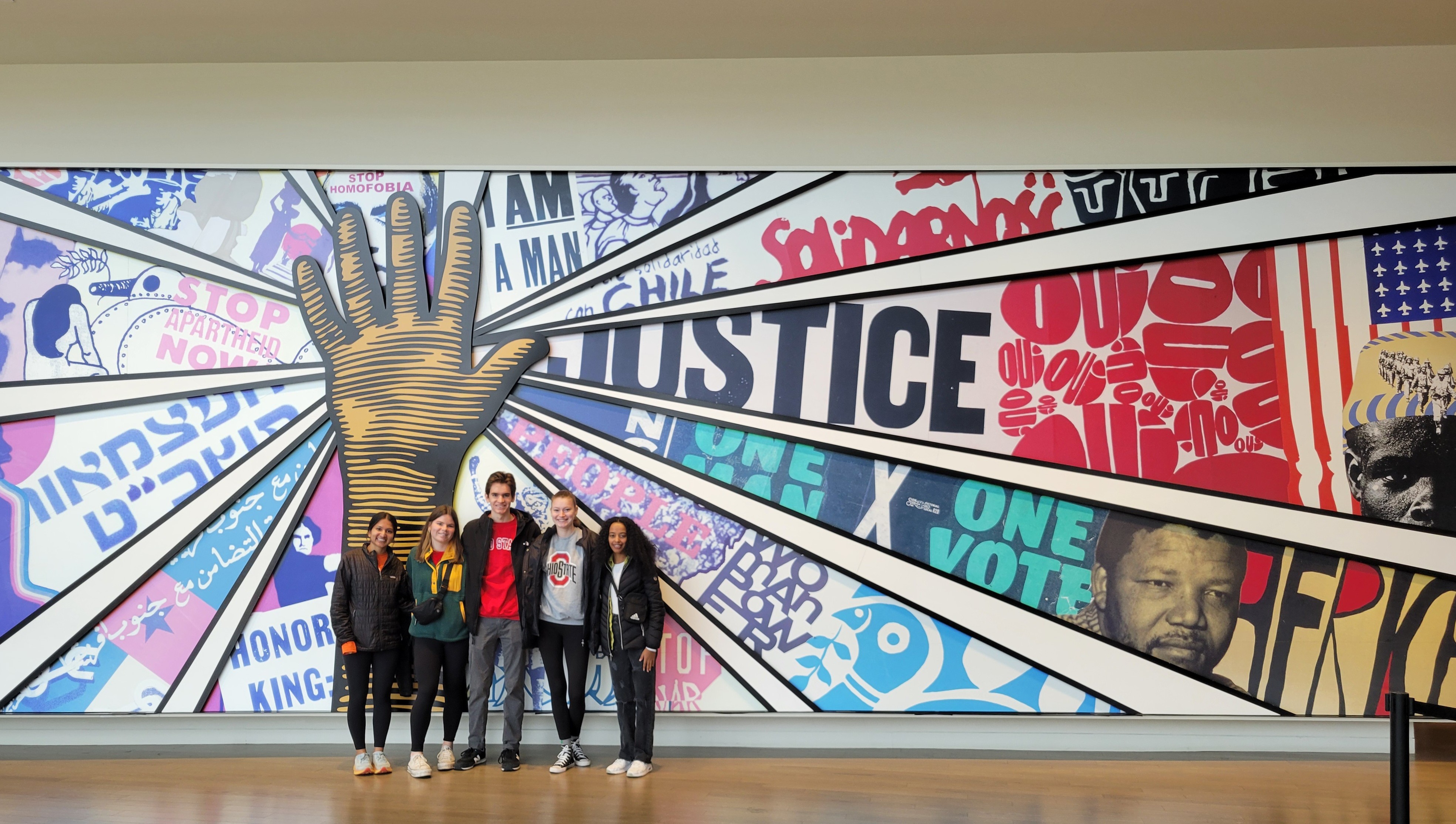 Five individuals standing in front of a mural at the National Center for Civil and Human Rights