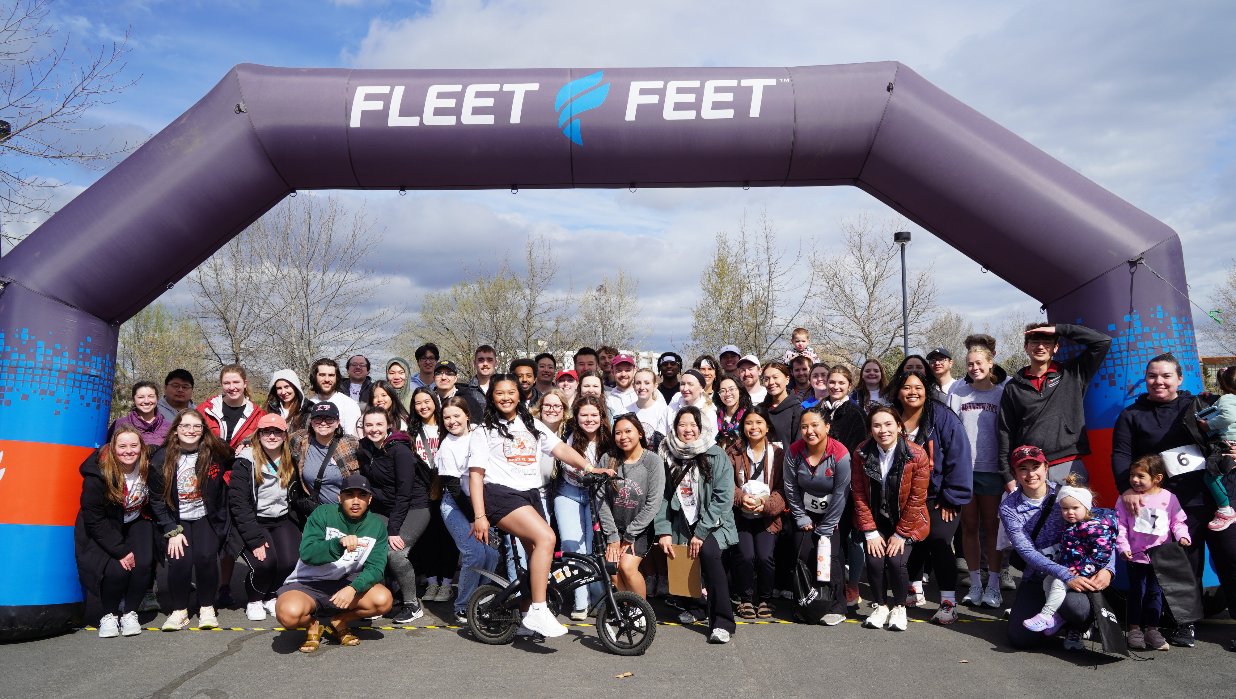 Kappa Psi brothers and participants in a group photo at the finish line