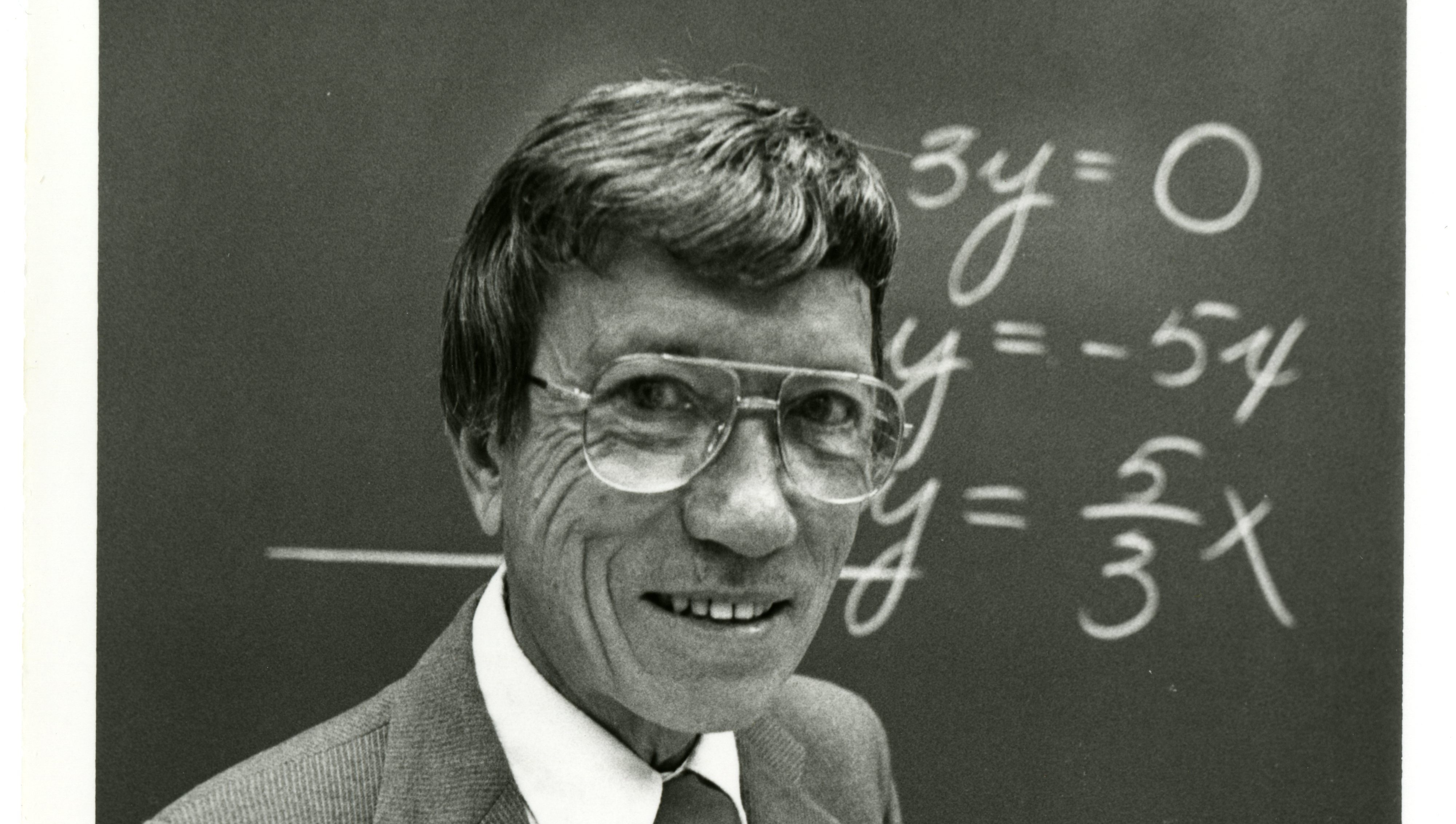 Hal standing before a mathematical equation on a blackboard