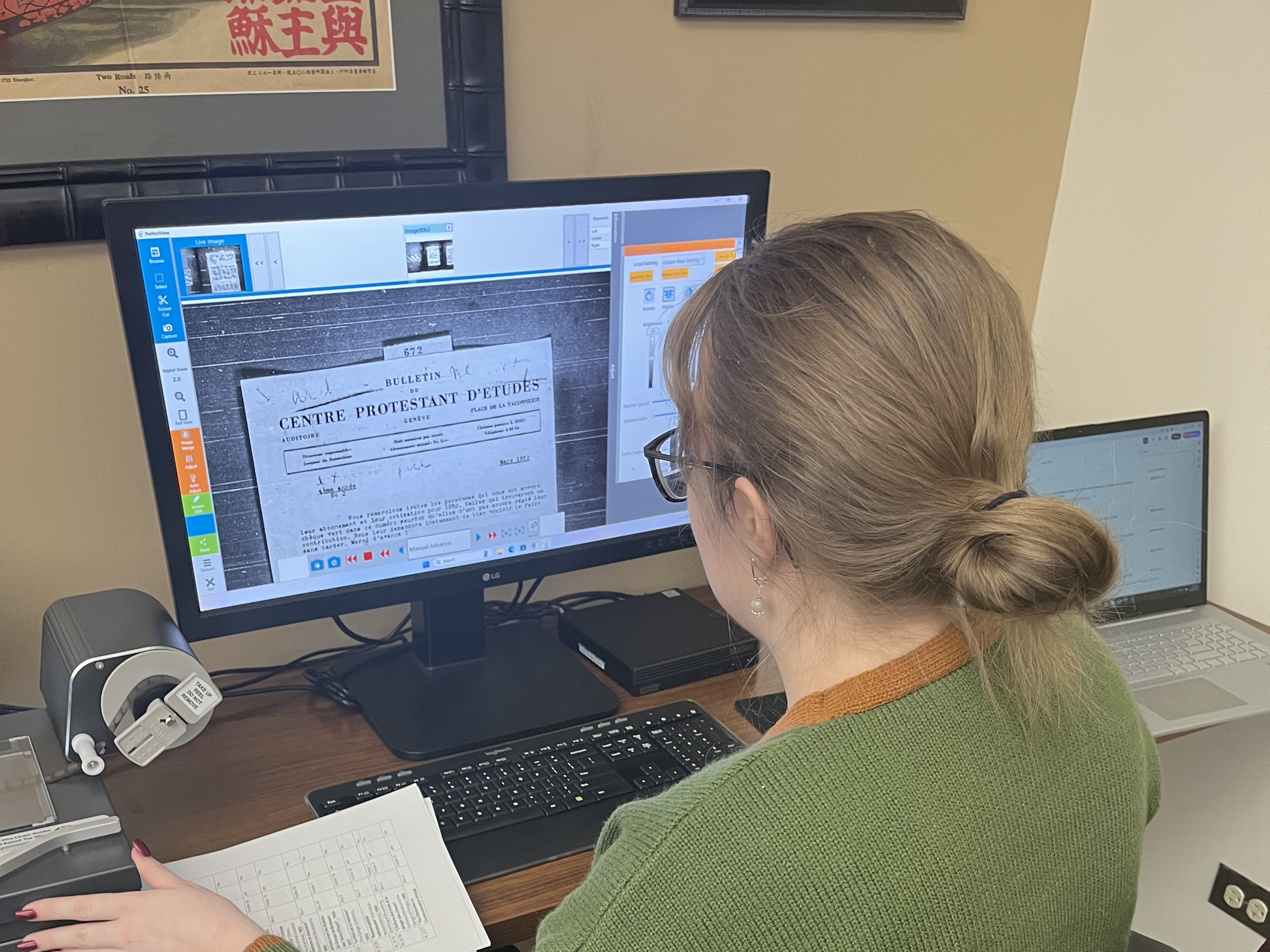 Moriah Pitts working with a microfilm reader to capture images of untranslated French documents.