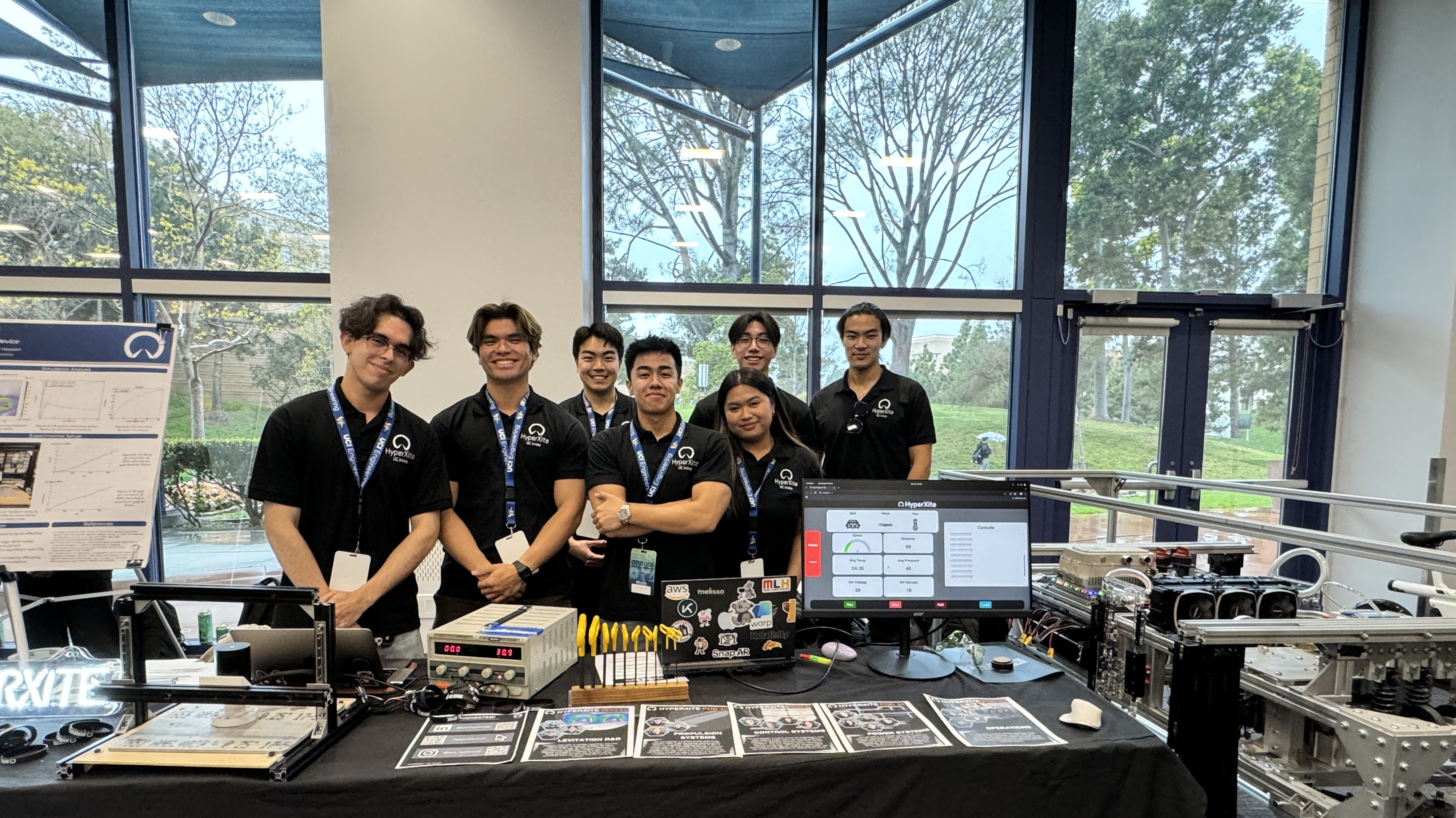 Engineering students on the HyperXite team with project pieces and data displayed