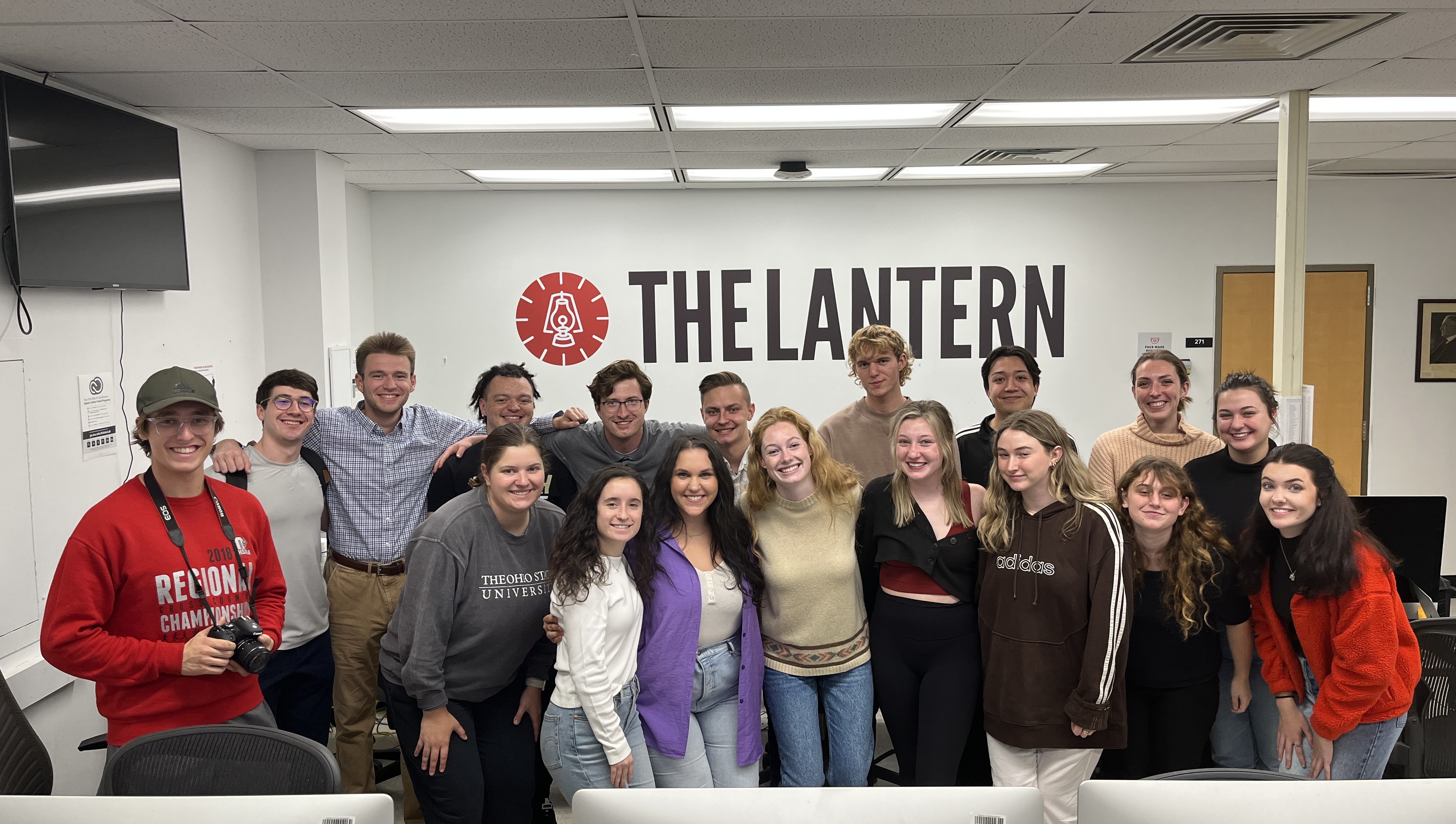 Group of students smiling in The Lantern's newsroom