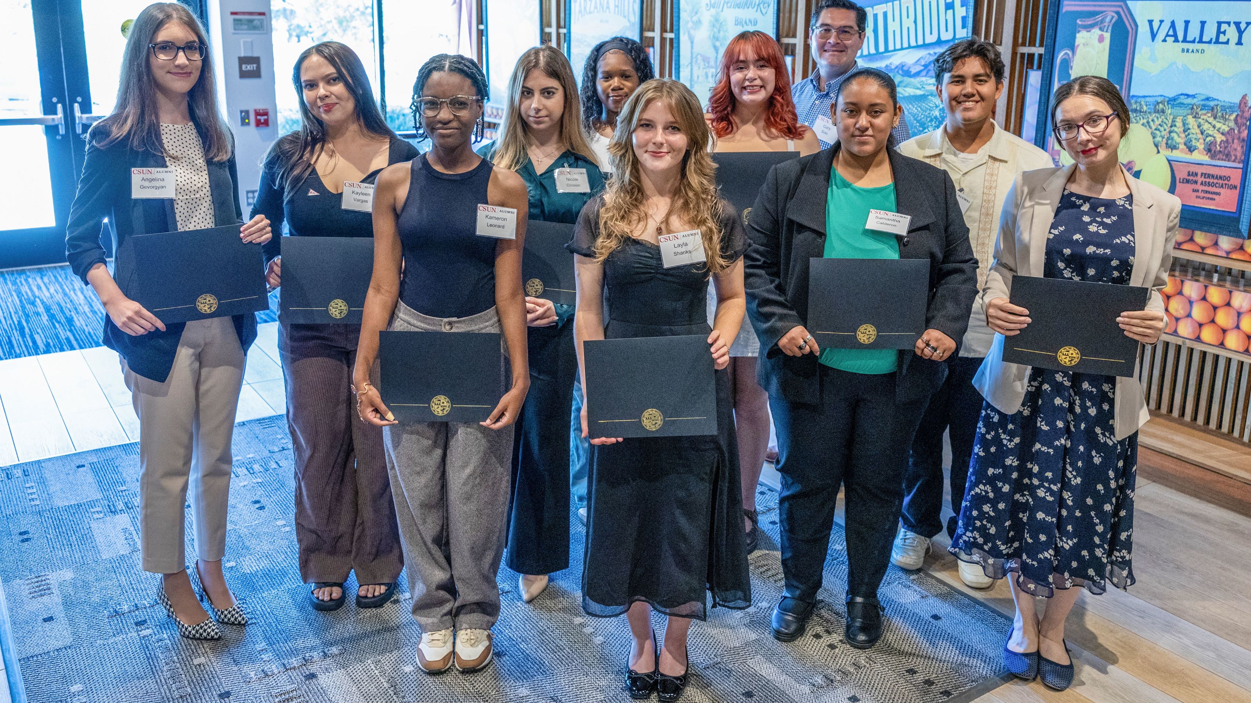 Group of CSUN Alumni Scholarship recipients pose together holding certificates at award ceremony.