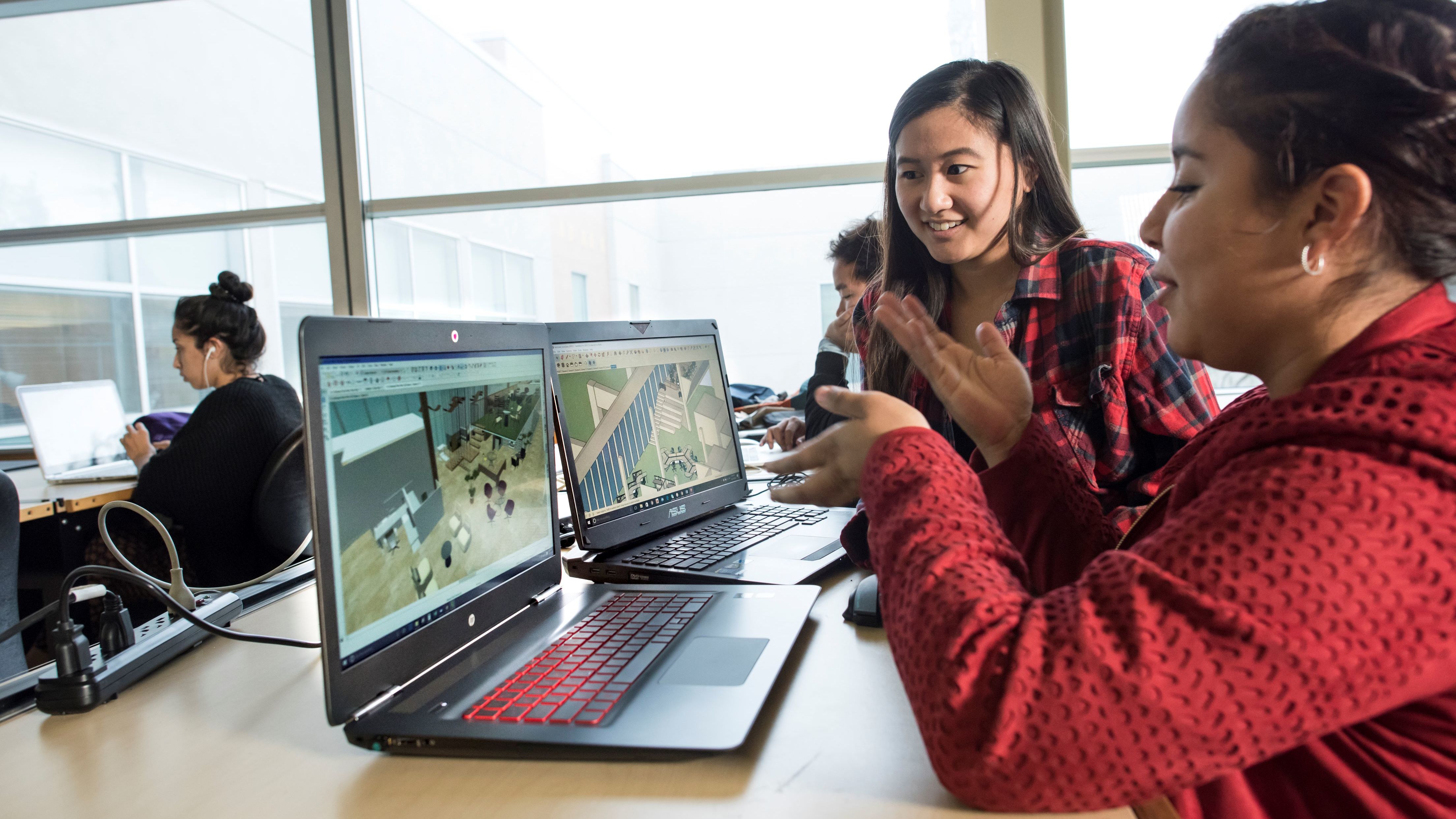 Two students working on a laptop
