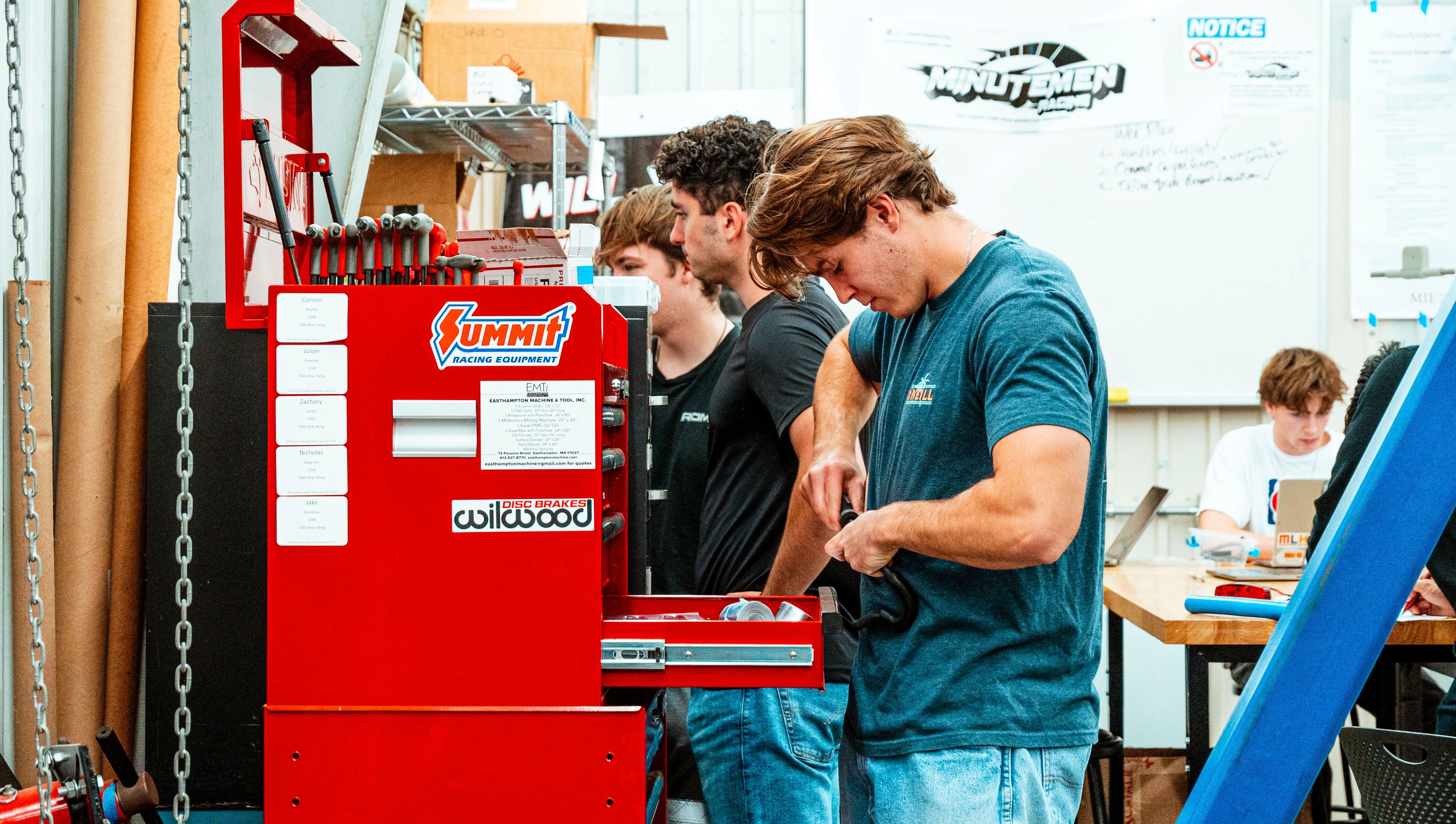 Minutemen racing students working on their car.
