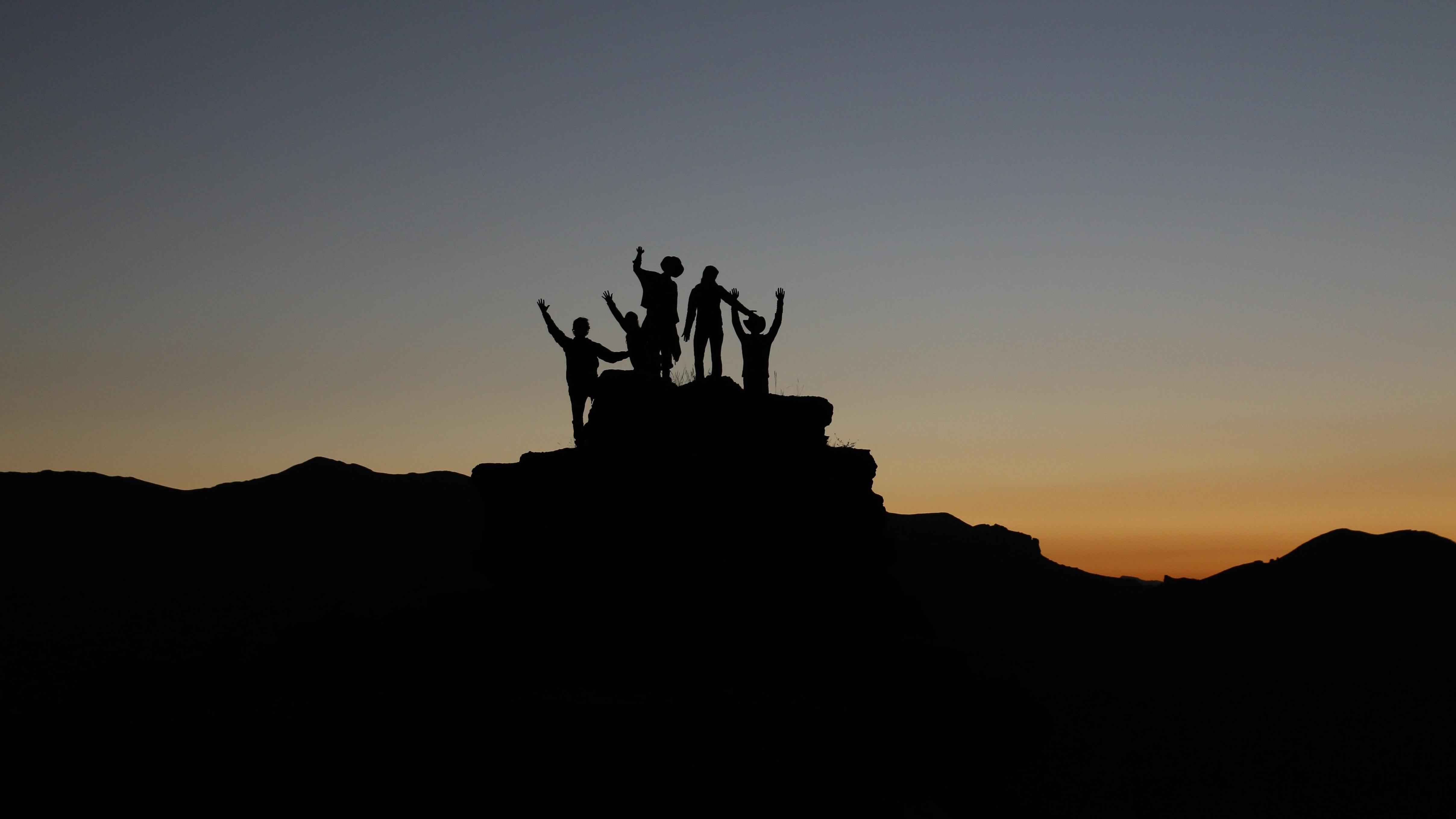 Leaders on a mountain at sunset