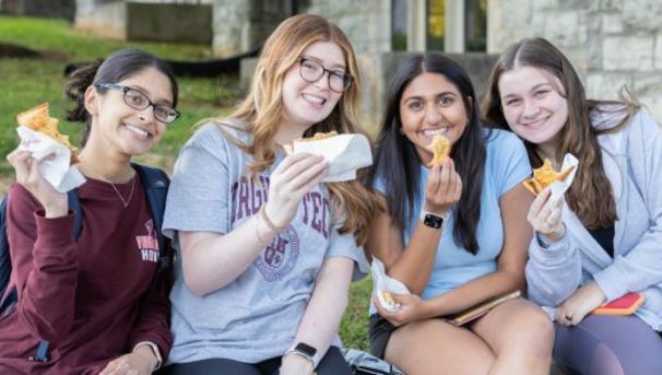 Students bite into a Cheesy Nights grilled cheese sandwich.