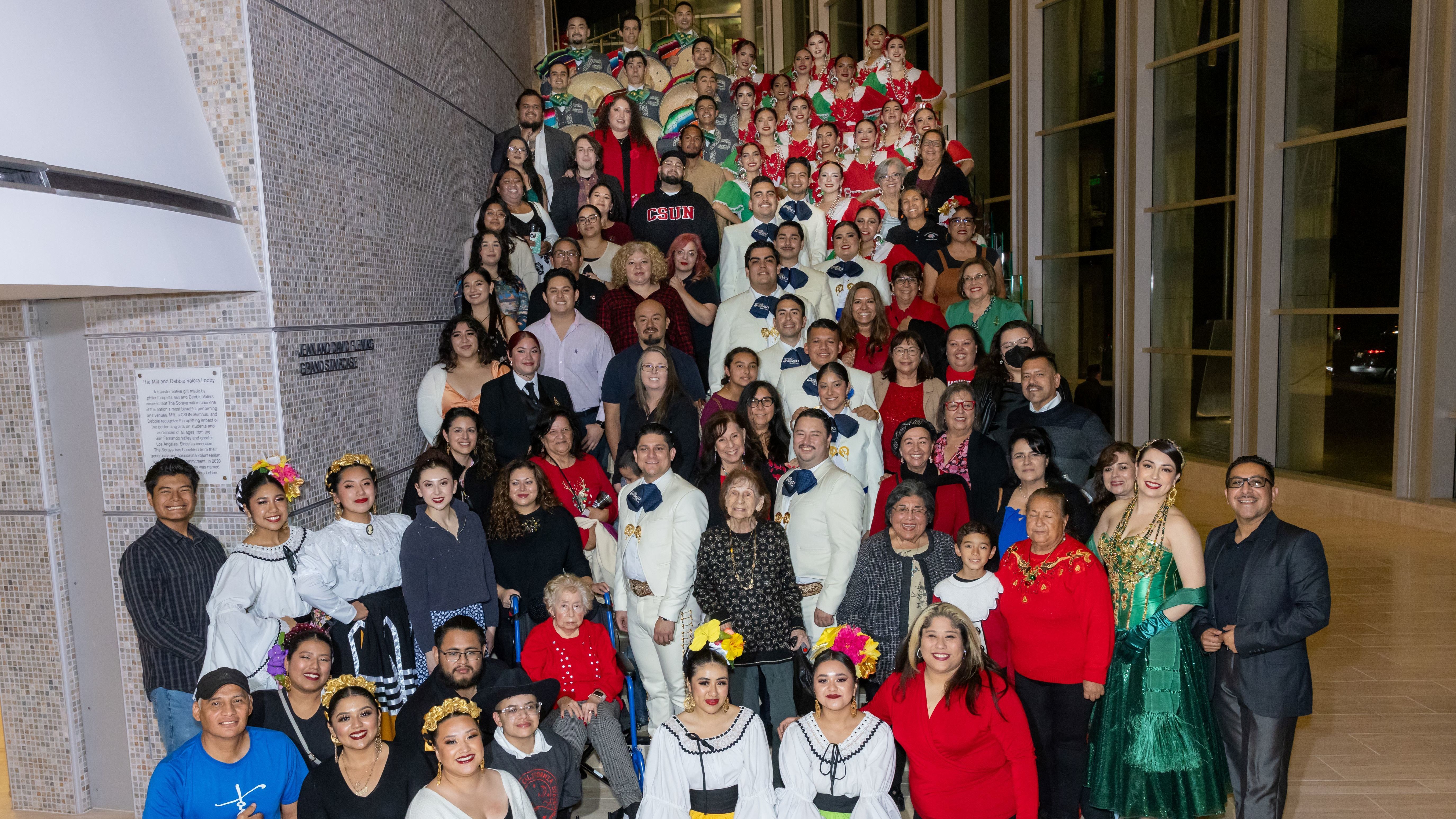 Group of students and performers standing on the stairs at the Soraya