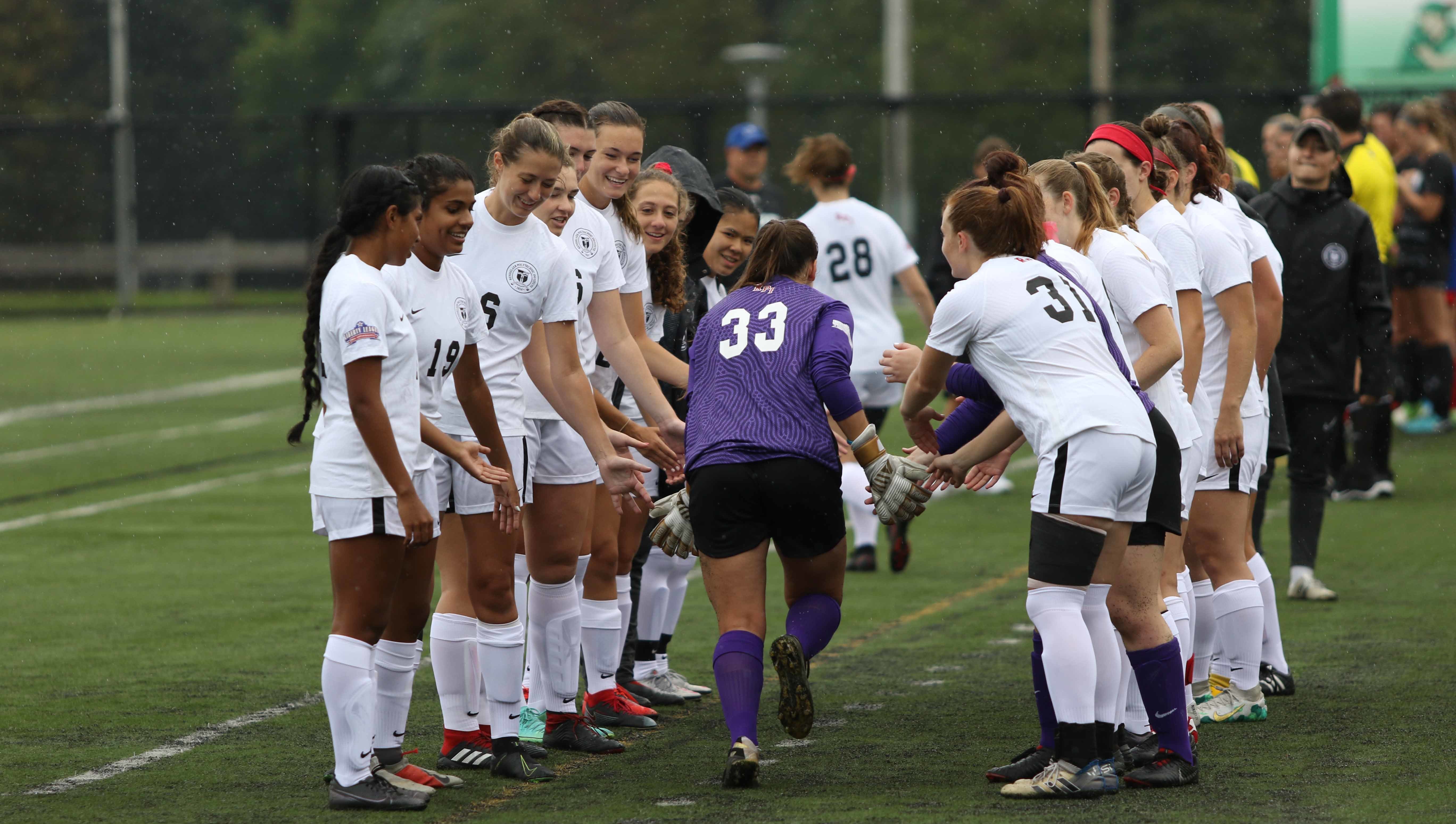 Members of the women's soccer team lined up on the field.