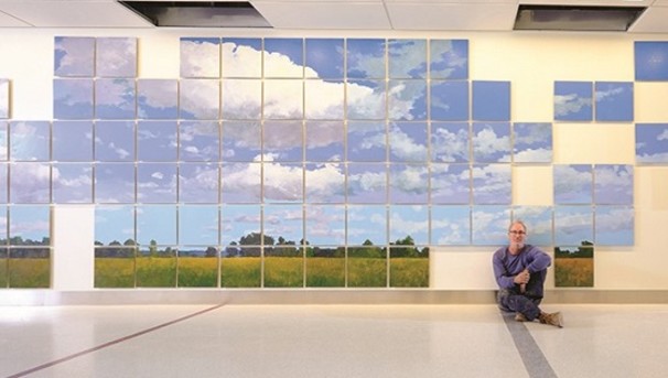 Individual sitting on the floor in front of the Breath of Hope Ohio mural