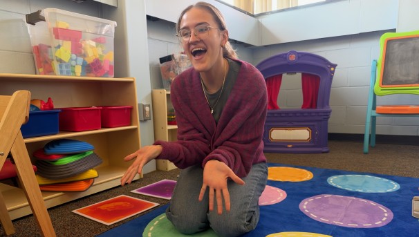 Student providing therapy in a colorful room with activities and toys.