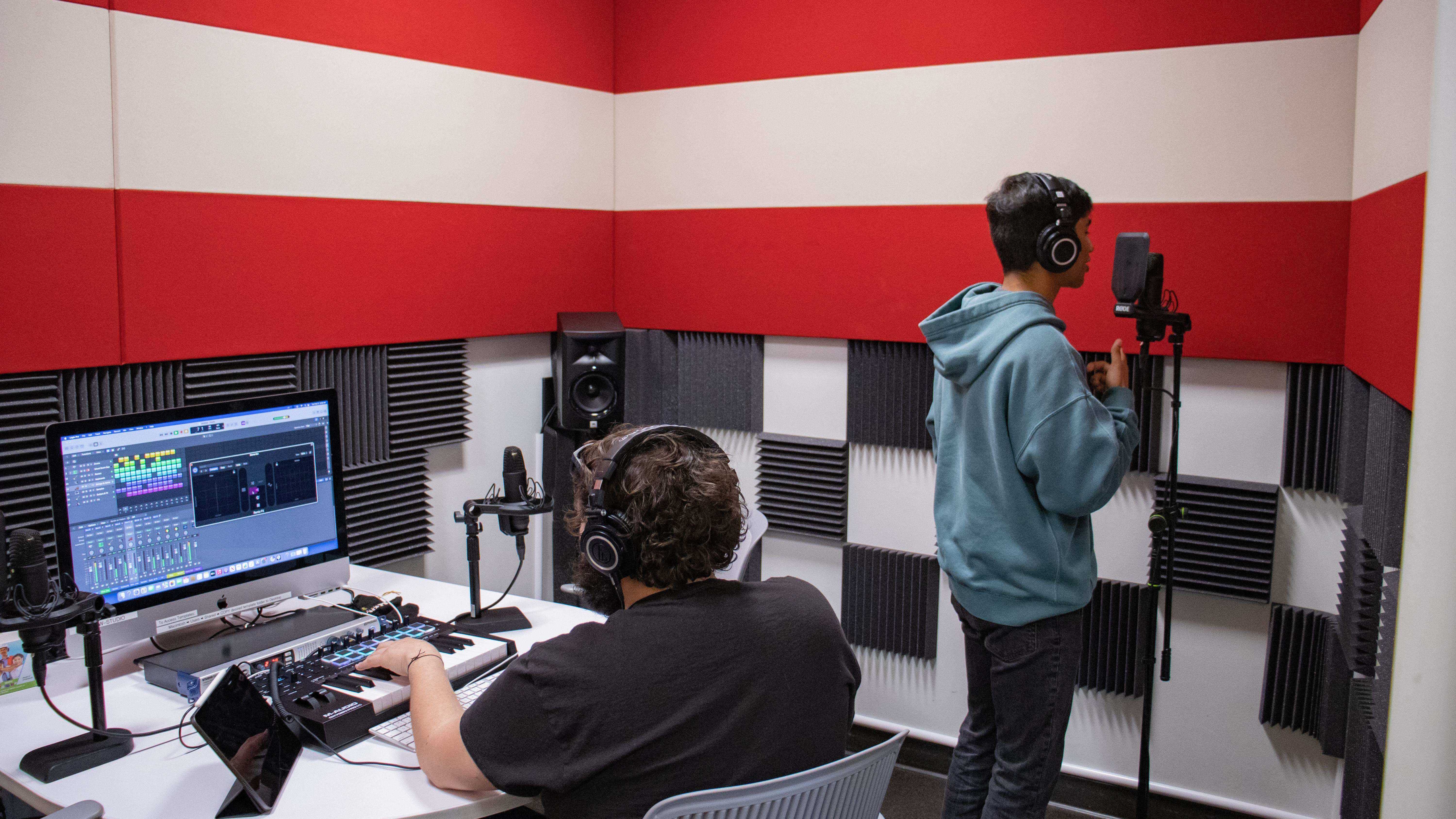Students record and mix audio in soundproof studio using pro-grade equipment.