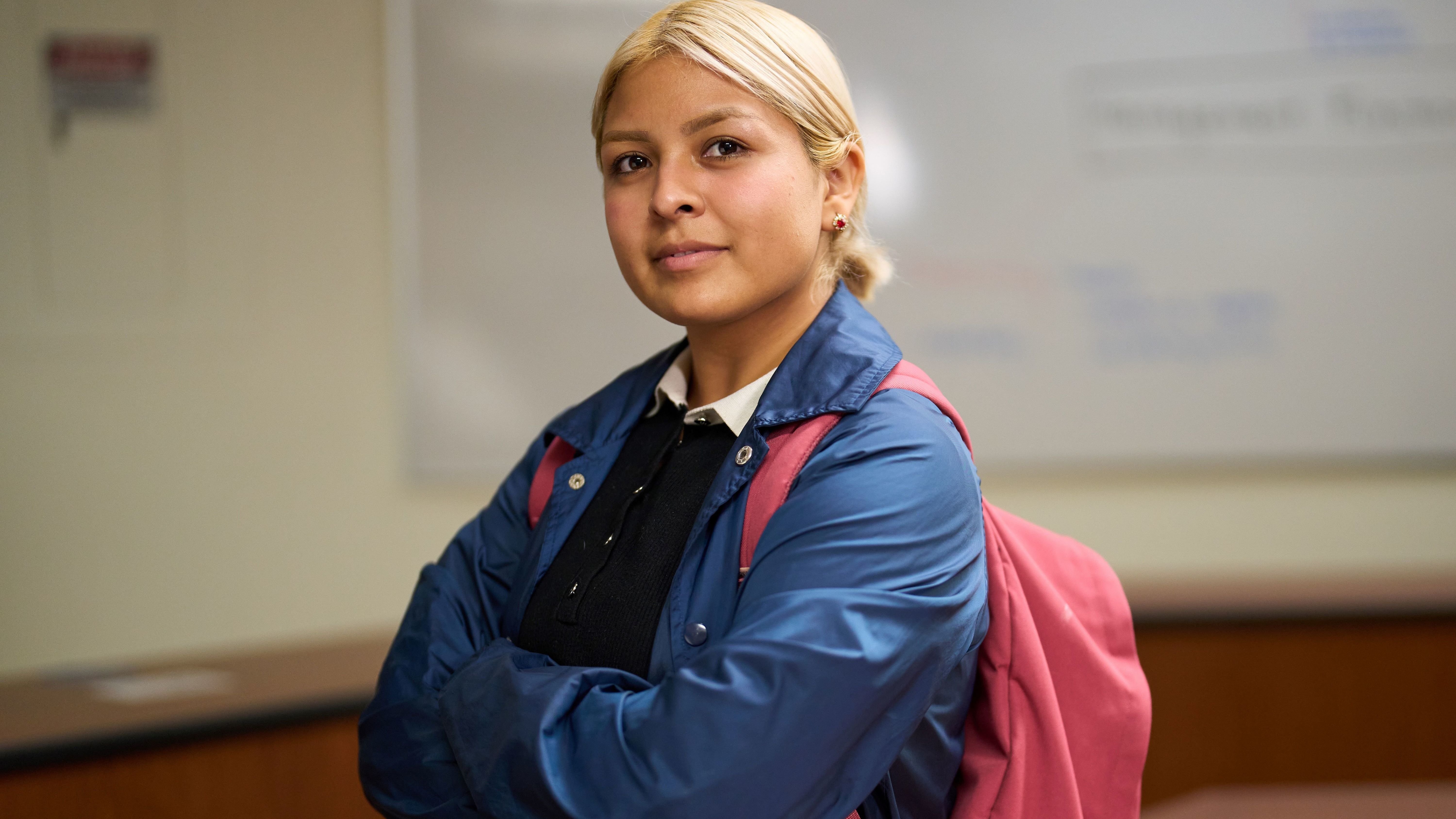Student with backpack in classroom.