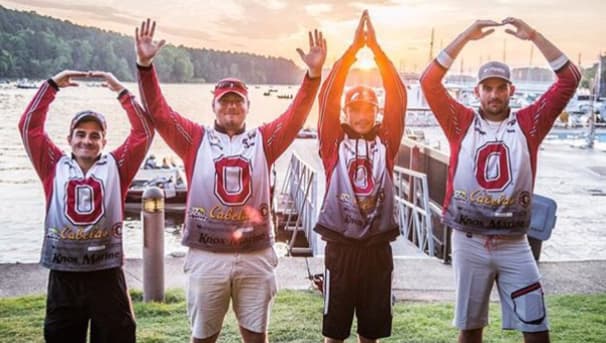 Four members in the Fishing Team uniforms. They raise their arms to spell OHIO