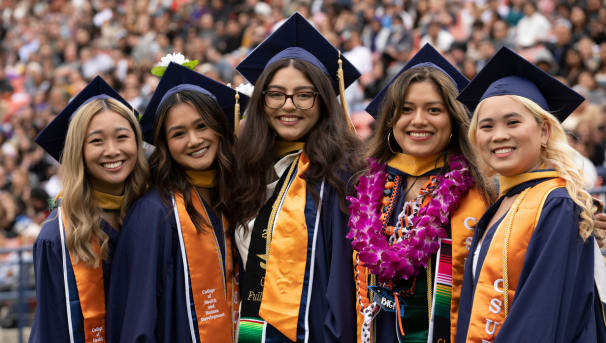 5 students smiling at the camera at Commencement