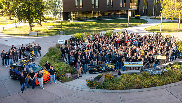 Group of Enterprise students surrounding the Husky statue.