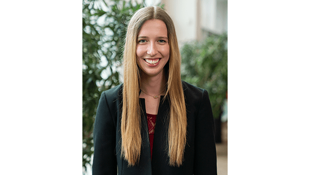Katherine McGreal's professional headshot. She wears a black blazer and a dark red undershirt