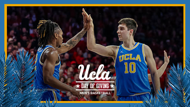 Men's Basketball teammates giving each other a high-five on the court.