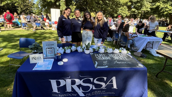 4 female PRSSA members tabling at Involvement Fair on campus