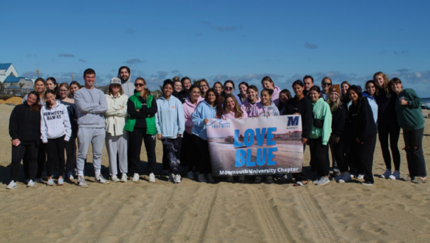 Large group of students posing for a group shot at a beach sweep