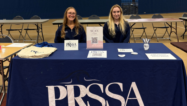 2 female PRSSA members tabling at Involvement Fair on campus