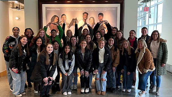 Group of individuals standing together smiling for a photo indoors