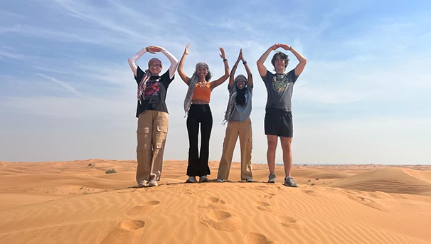 Students in the desert holding up their arms to spell OHIO