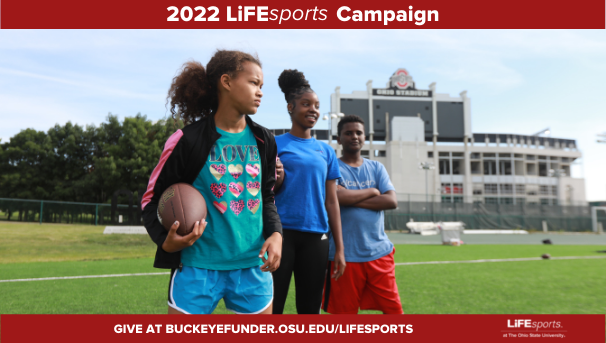 Three students on football practice field with OSU's Stadium behind them
