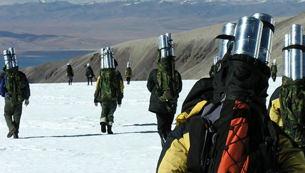Group of people walk across snow doing research in the field