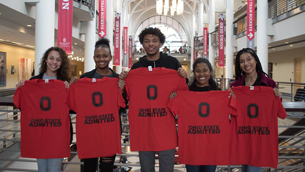 Five students in the Ohio Union standing together holding Ohio State Admitted tshirts