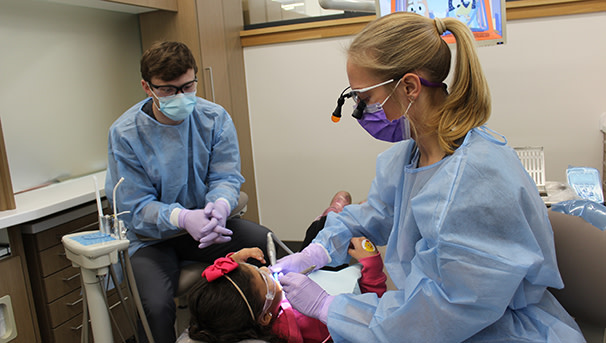 Dental students performing a cleaning