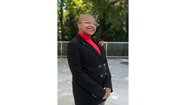 Ose Arheghan's professional headshot. They wear a black blazer and red turtleneck
