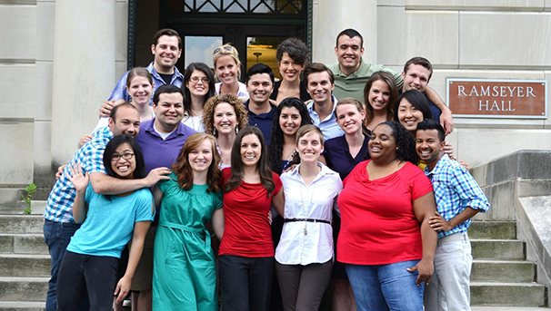 Individuals standing in a group outside on the steps of Ramseyer Hall