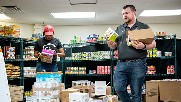 Individuals volunteering with unpacking boxed food at the food pantry